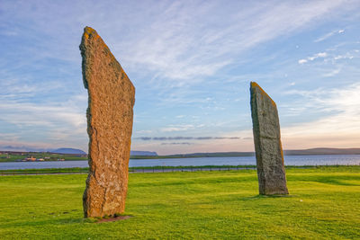 Wooden posts on field against sky