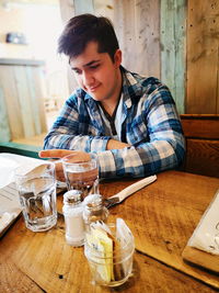 Boy with drinks on table sitting at restaurant