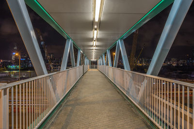 Empty illuminated footbridge in city