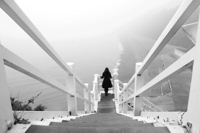 Rear view of people walking on bridge