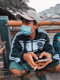 Full length of young man using mobile phone