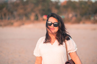 Portrait of young woman wearing sunglasses while standing outdoors