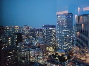 Illuminated cityscape against sky at night