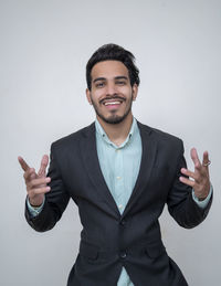 Portrait of young man standing against white background