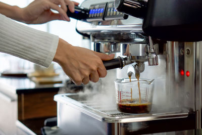 Cropped image of hand pouring coffee in cafe