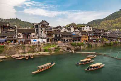 Boats in canal by buildings in city