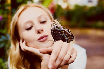 Brown butterfly sit at woman hand
