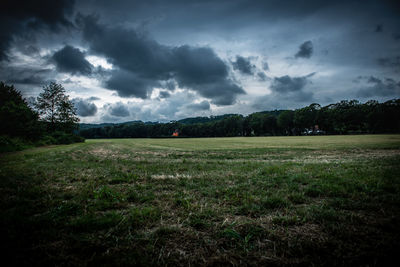 Scenic view of field against cloudy sky