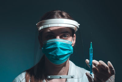 Female doctor hero with mask and face shield holfing vaccine