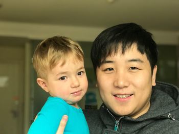 Portrait of smiling man and boy at home