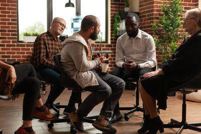 People sitting on chair while having psychotherapy session