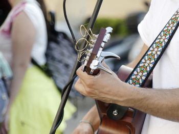 Midsection of man playing guitar