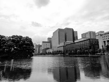 Reflection of buildings in city against sky