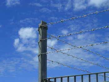 Low angle view of cranes against blue sky