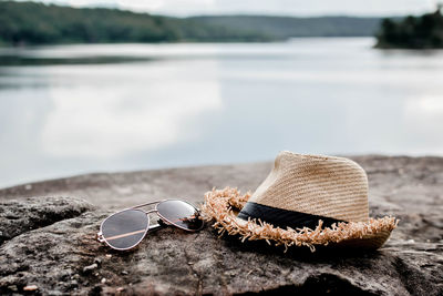 View of sunglasses and hat by lake