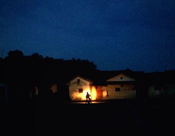 Illuminated house against sky at night