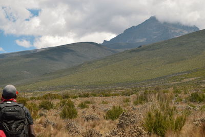 Rear view of man on mountain against sky