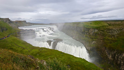 Scenic view of waterfall against sky