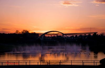 View of bridge over river at sunset