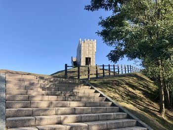 Low angle view of staircase against clear blue sky