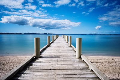 Wooden jetty leading to calm blue sea