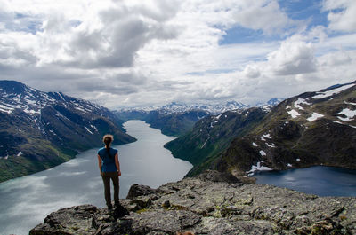 Rear view of female hiker looking out from the top of besseggen over the gjende and bessvatnet lake