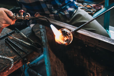 Close-up of man working on metal in factory