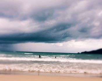 Scenic view of beach against cloudy sky