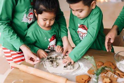 Asian family with two children in pajamas prepare festive food for the christmas holiday at home