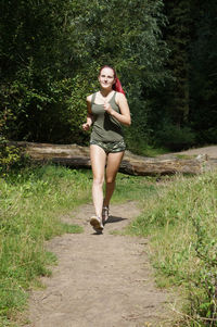 Young woman jogging on footpath at field