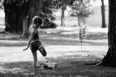 Full length of girl with arms raised on grass