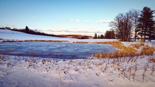 Scenic view of snow covered landscape against sky during sunset