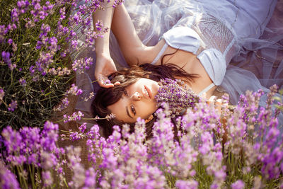 High angle view of woman lying on flowering field