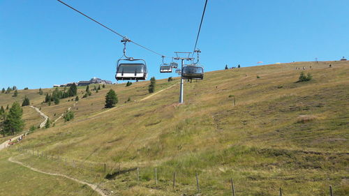 Low angle view of overhead cable car against clear blue sky