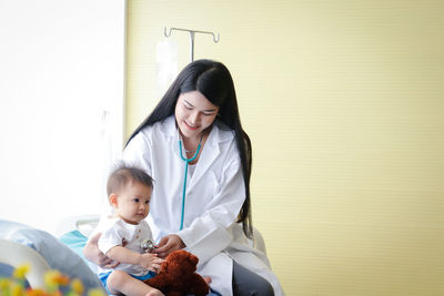 Female doctor examining cute boy in hospital