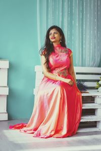 Beautiful young woman sitting on bench at home