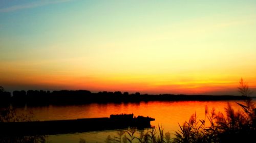 Scenic view of lake against romantic sky at sunset