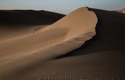 Scenic view of sand dune in desert against sky