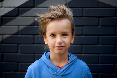 Portrait of boy against wall outdoors