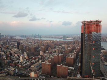 Aerial view of buildings in city against sky