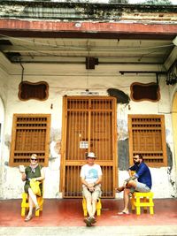 Full length of people sitting on doorway