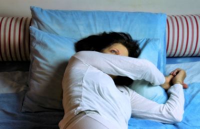 Midsection of woman lying on bed