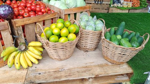 Fresh banana, lime, guava, green chayote, cucumbers red tomatoes in rattan wicker baskets