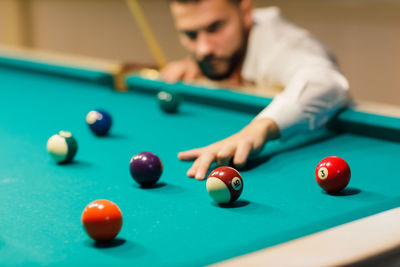 Midsection of man playing pool