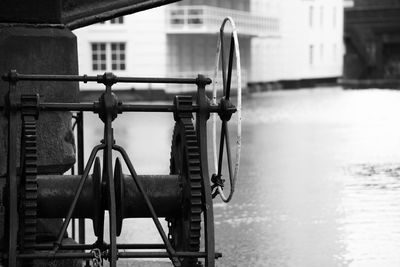 Metallic machinery in river against building