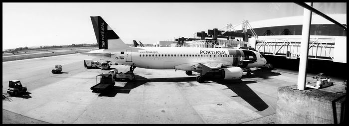 Airplane on airport runway against sky