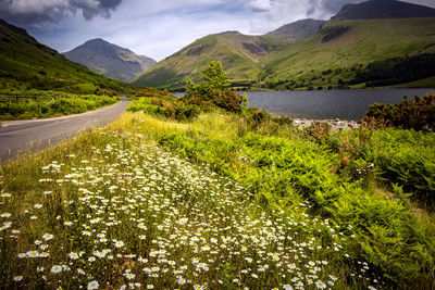 Scenic view of lake by mountains against sky