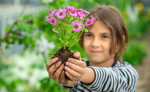 Girl holding plant of flower