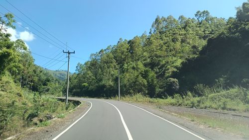 Road amidst trees against sky