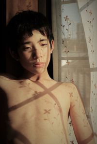 Portrait of shirtless boy standing at home